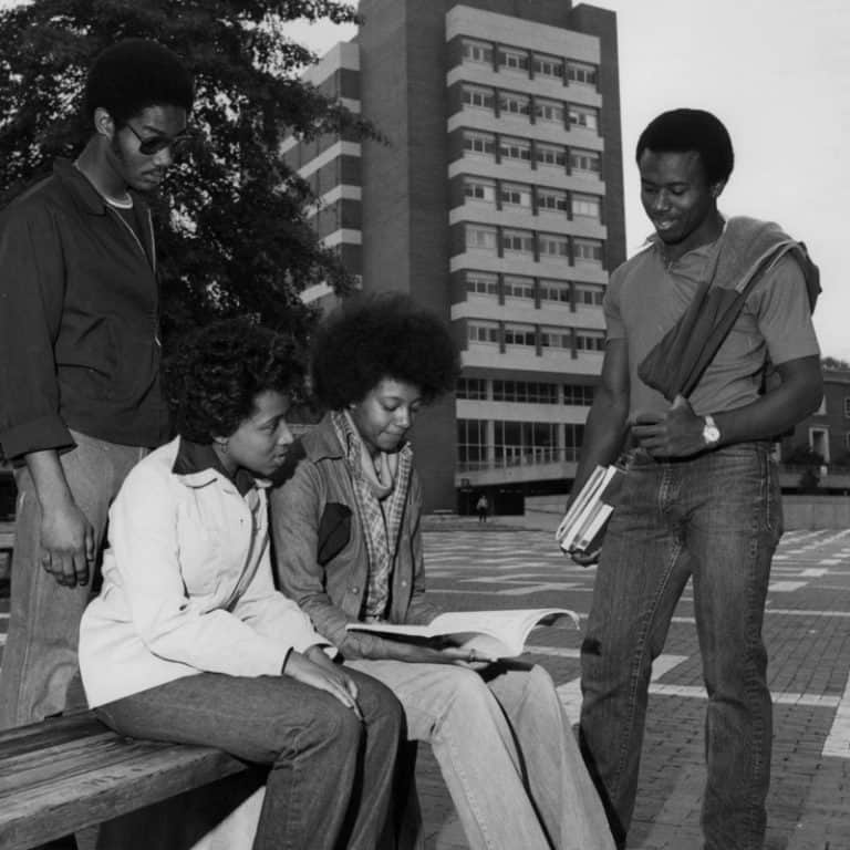 Students sit on a bench in the brickyard