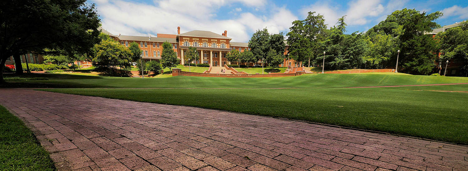 A view of the 1911 Building shot from across the lush, green Court of North Carolina.