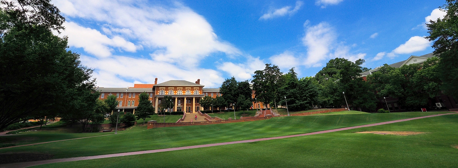 A view of the 1911 Building shot from across the lush, green Court of North Carolina.