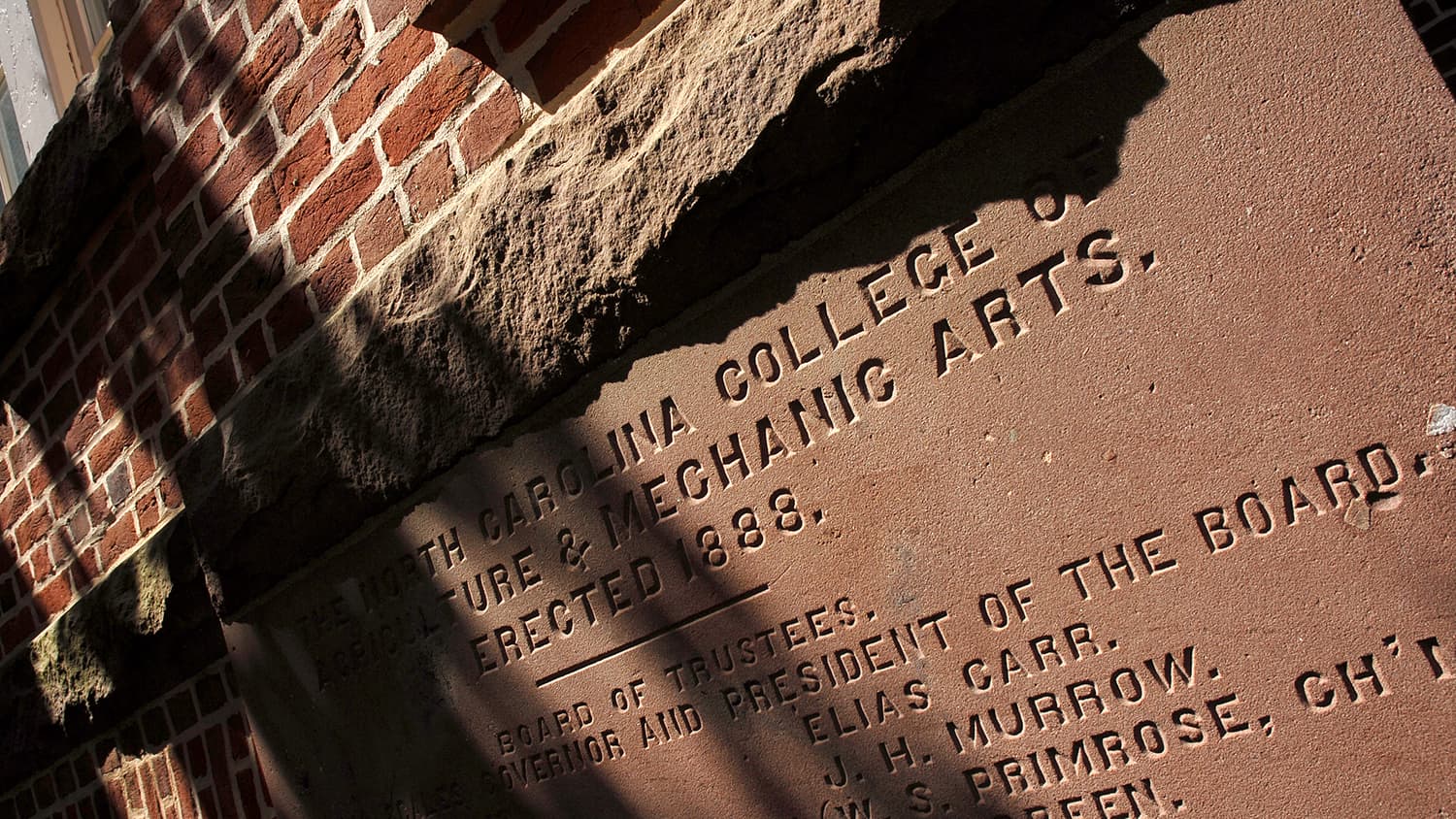 A cornerstone of Holladay Hall highlights the university's original name, reading: "The North Carolina College of Agriculture and Mechanic Arts, Erected 1888."