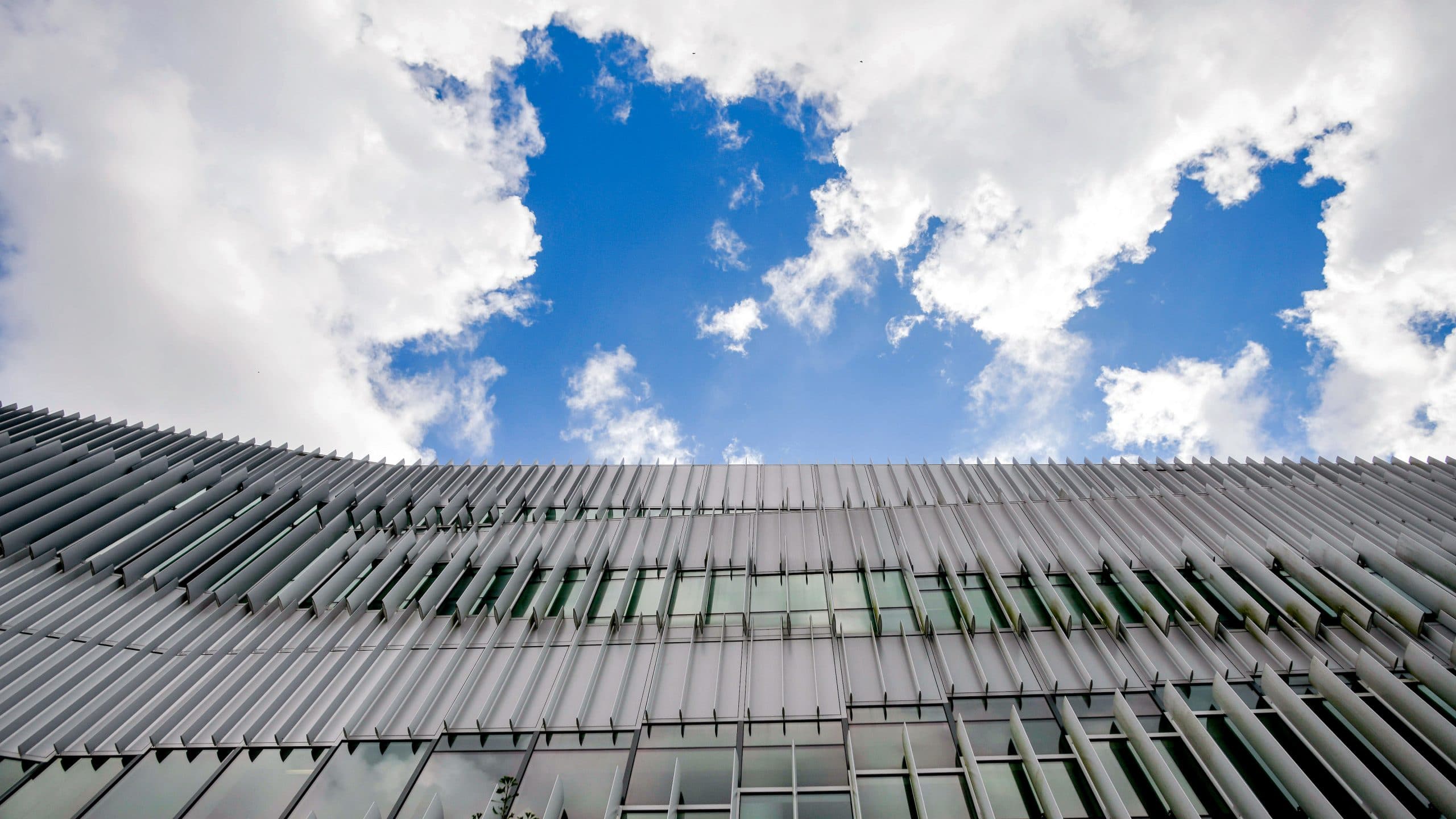 Hunt Library under parting clouds and blue skies.
