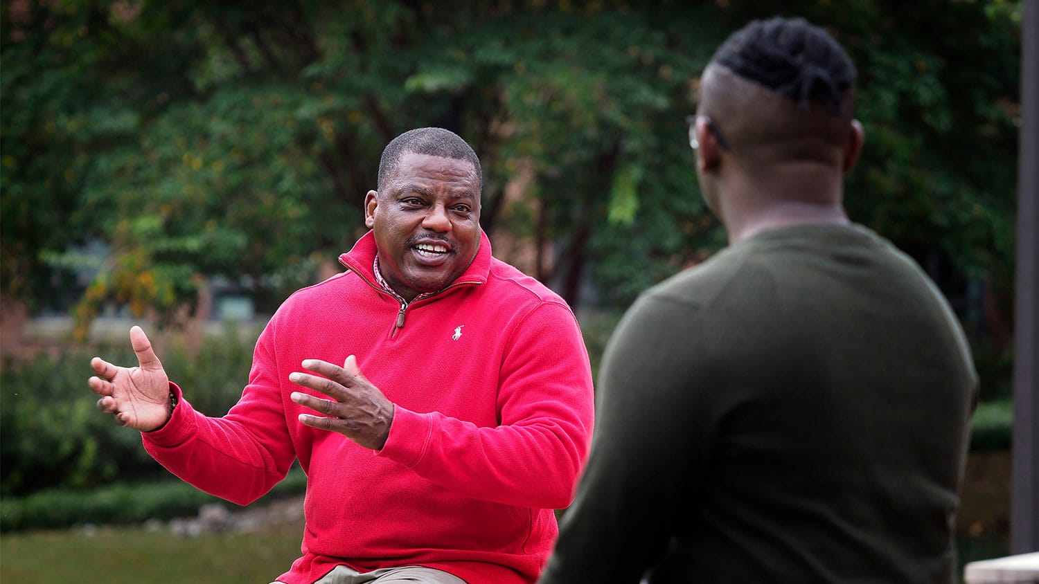 Joe Johnson, student diversity coordinator in the College of Humanities and Social Sciences, speaks with an undergrad student in the Court of North Carolina.