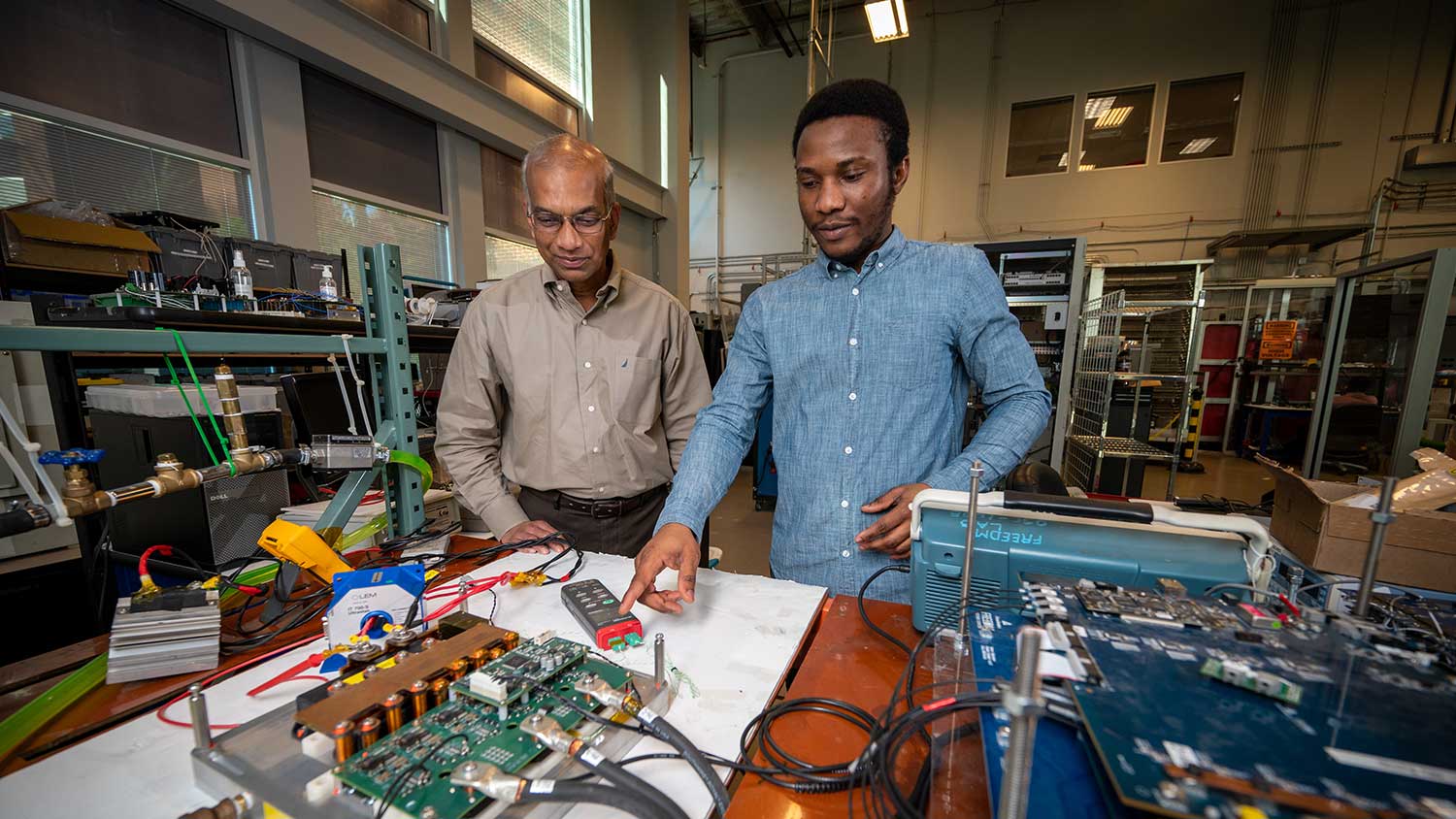 Iqbal Husain works with a graduate student inside of the FREEDM Center on Centennial campus.