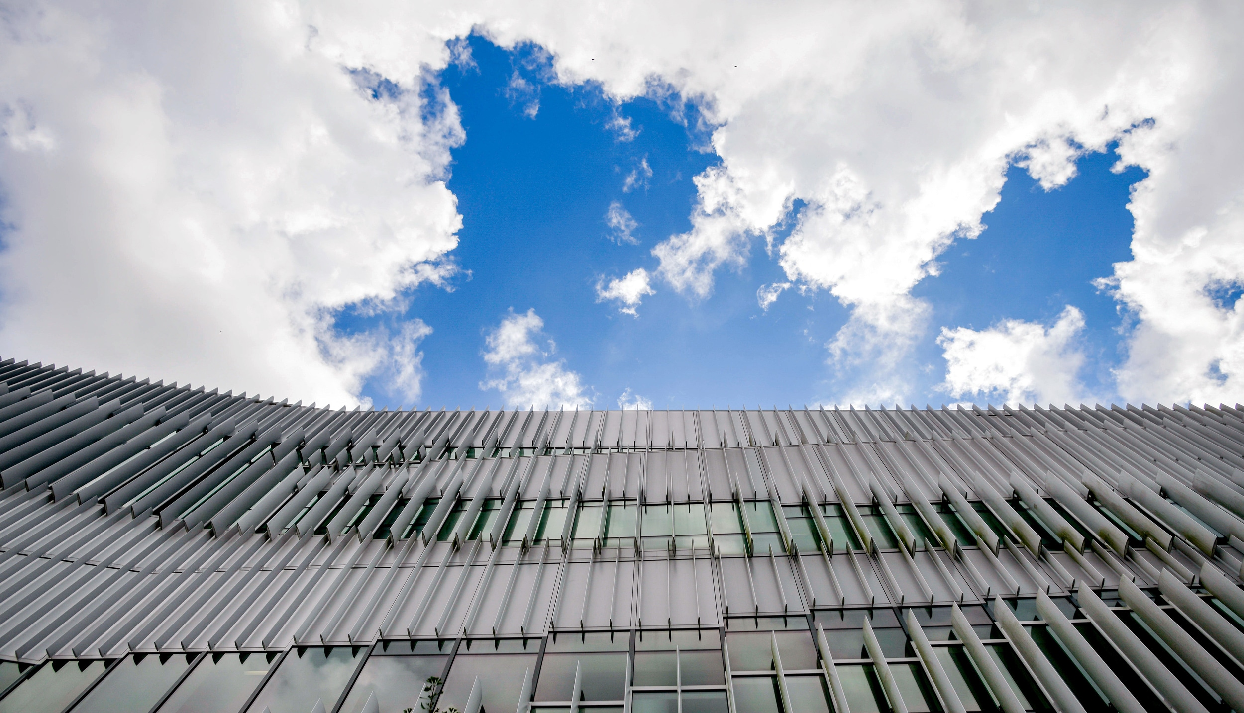 Hunt Library under parting clouds and blue skies.