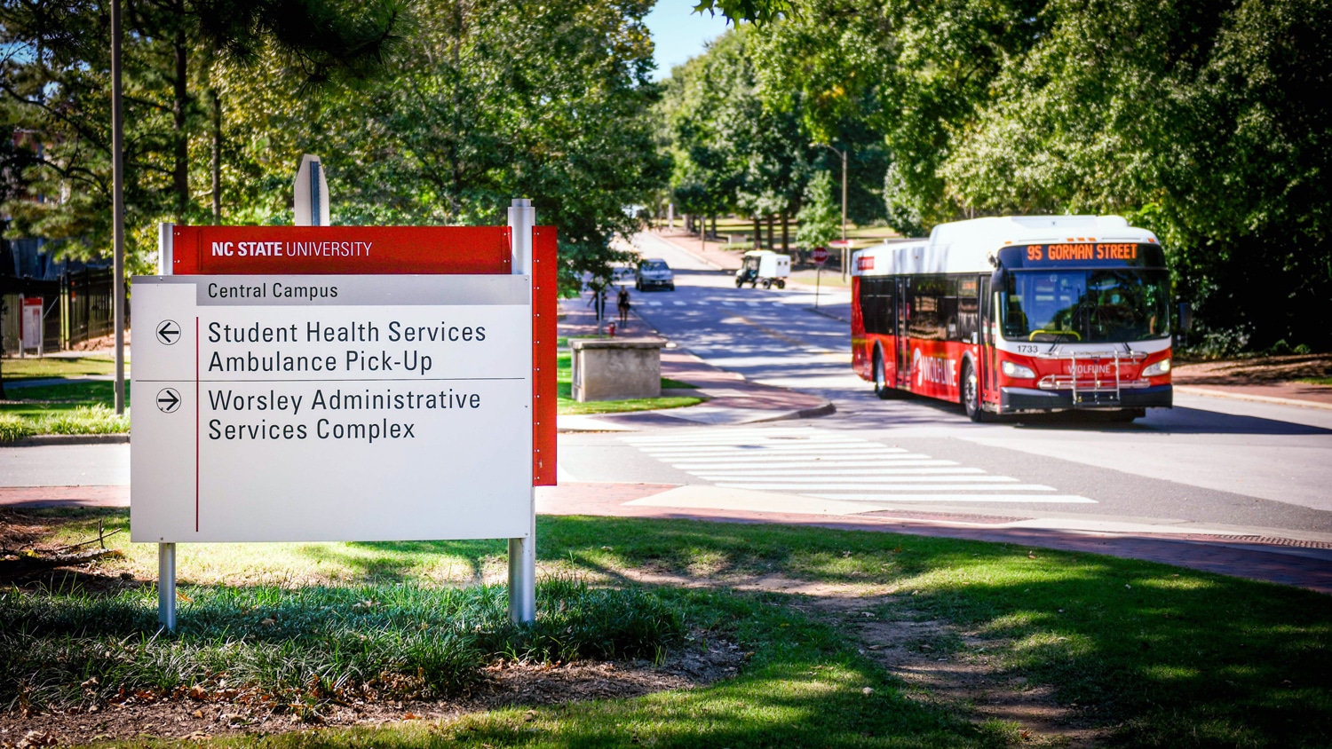 An NC State Wolfline bus moves people on campus on a spring day.