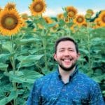 Online and Distance Education student AG Osborne in a sunflower field.