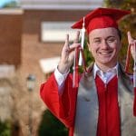 NC State graduate Dylan Inman puts up the wolf ears in his graduation regalia.