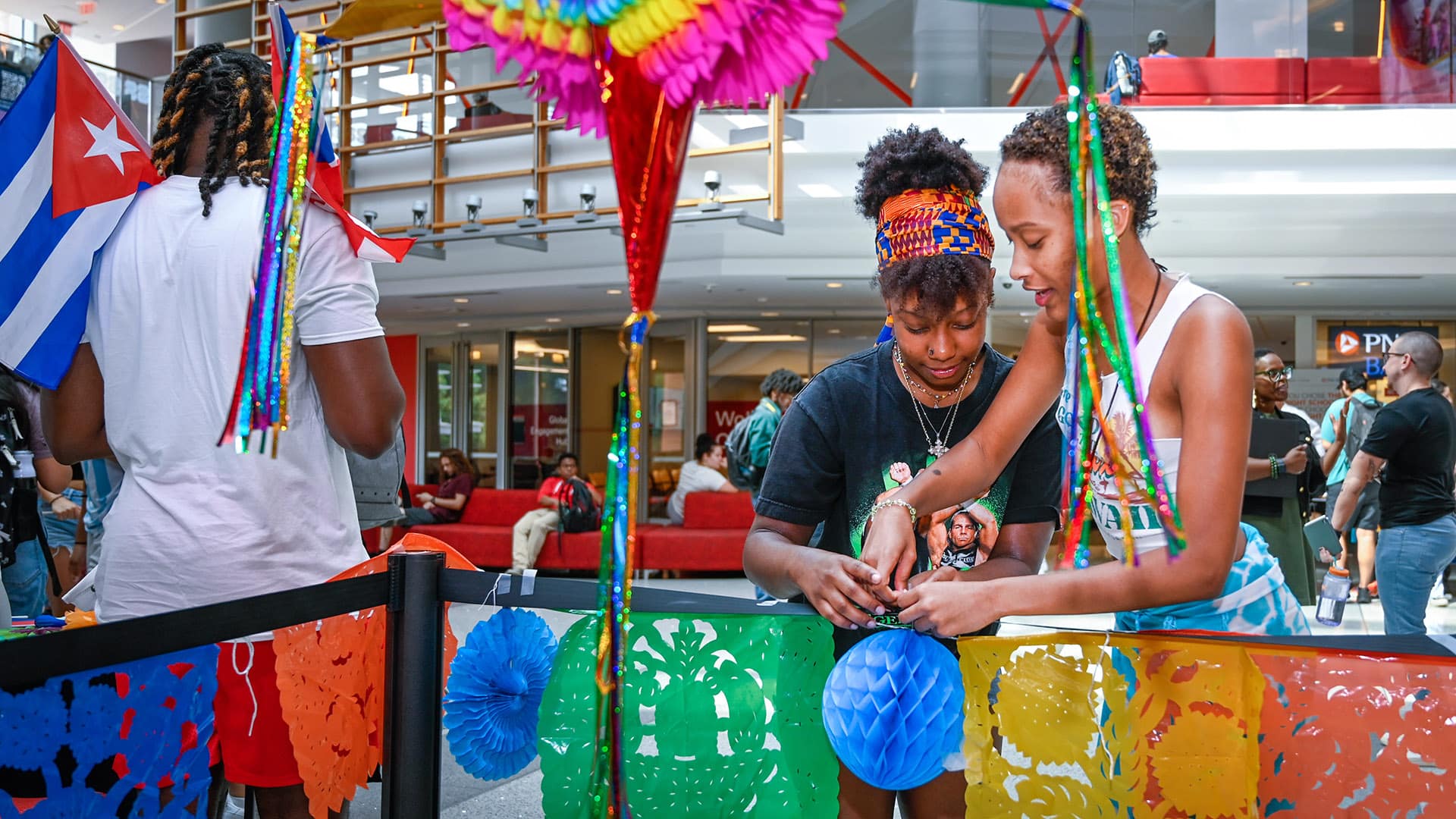 Students tweak the decorations at the Latinx Heritage Month kickoff in Talley Student Union