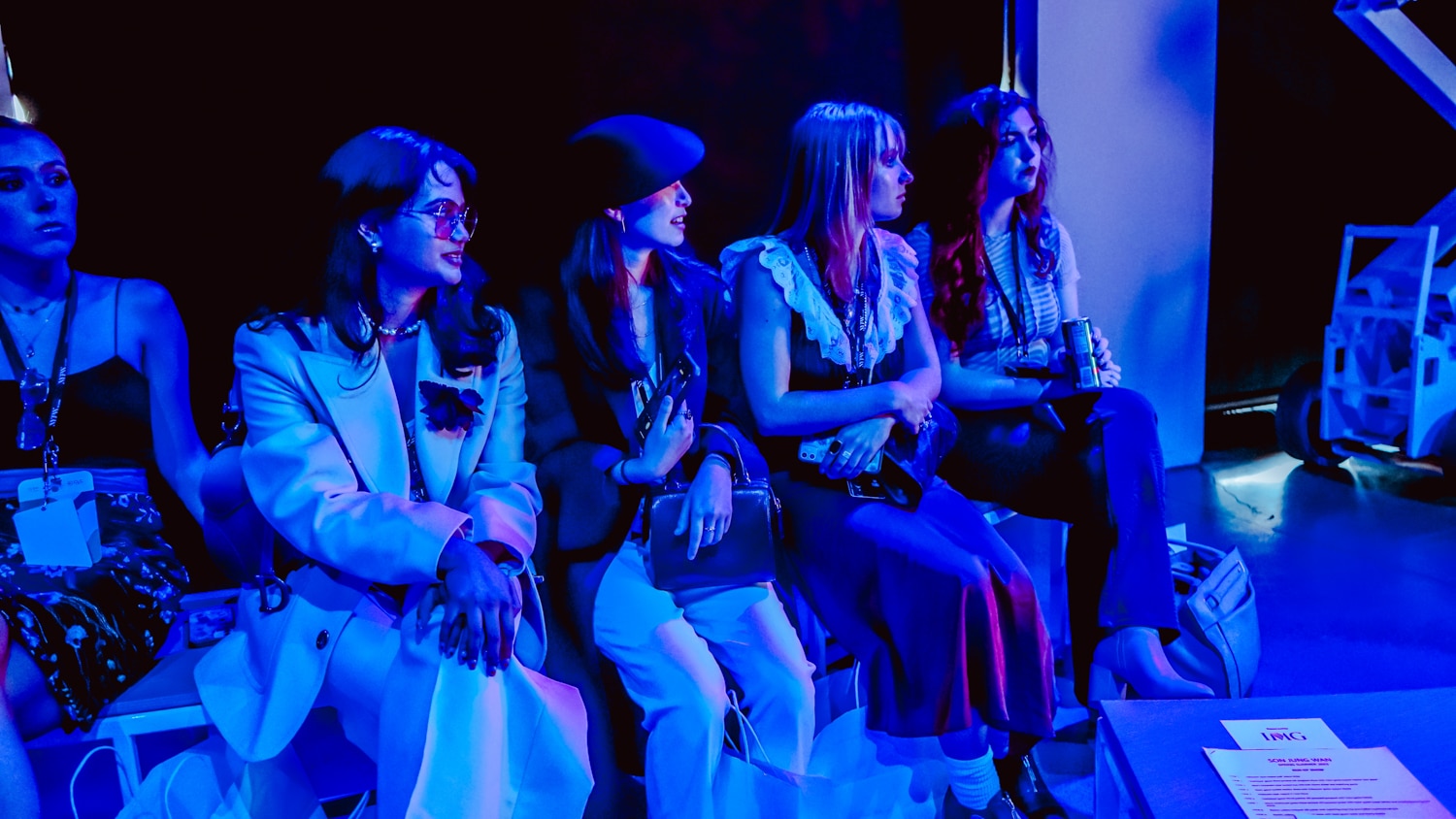 A group of women suffused in blue light at New York Fashion Week.