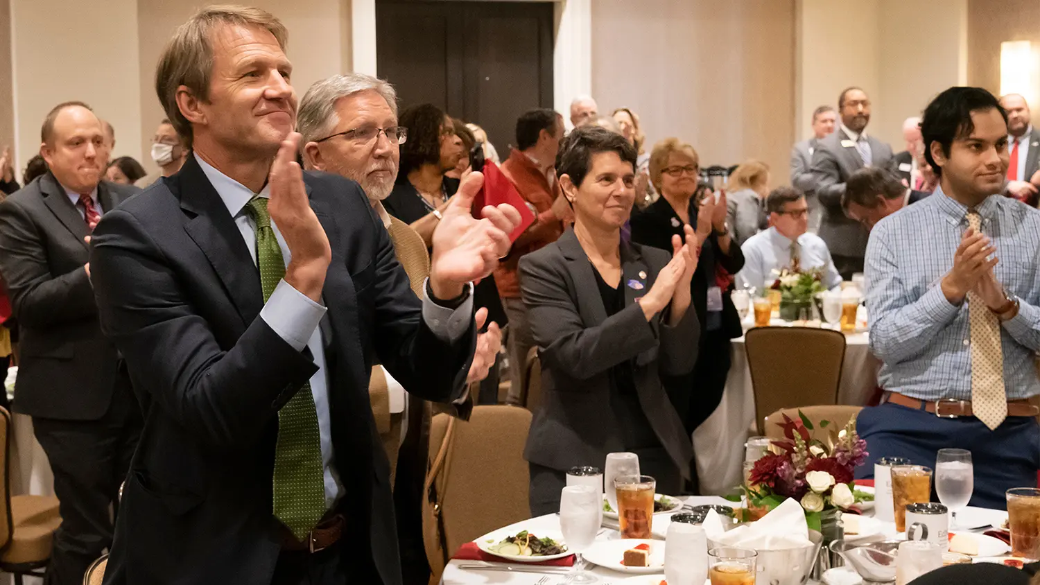 Members of the College of Education at NC State applaud during an event.