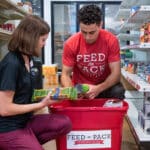 Two student volunteers work at Feed the Pack, NC State's on-campus food pantry.