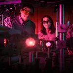 Kory Green, former postdoctoral researcher, and Shuang Fang Lim and Hans Hallen, both faculty members in the Department of Physics, work in a laser lab in Riddick Hall.