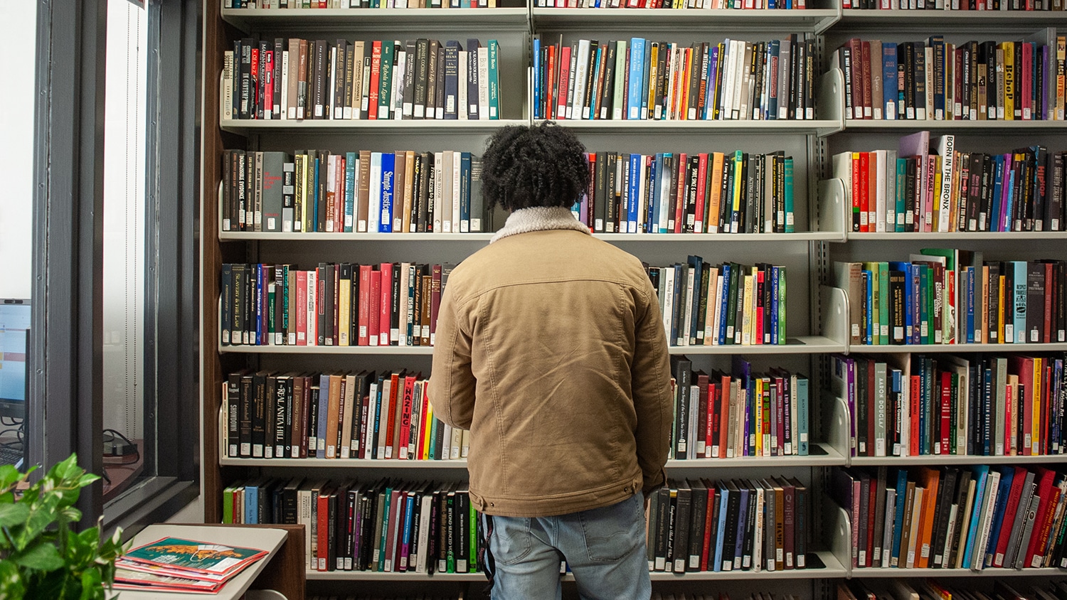 An NC State student explores the African American Cultural Center's robust library.