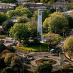 An aerial photo of NC State's main campus highlighting the Belltower and Holladay Hall.
