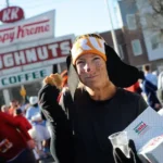 A contestant is all smiles as she eats a doughnut at the Krispy Kreme on Peace Street.