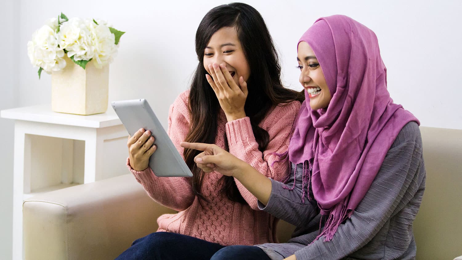 two women looking at a tablet