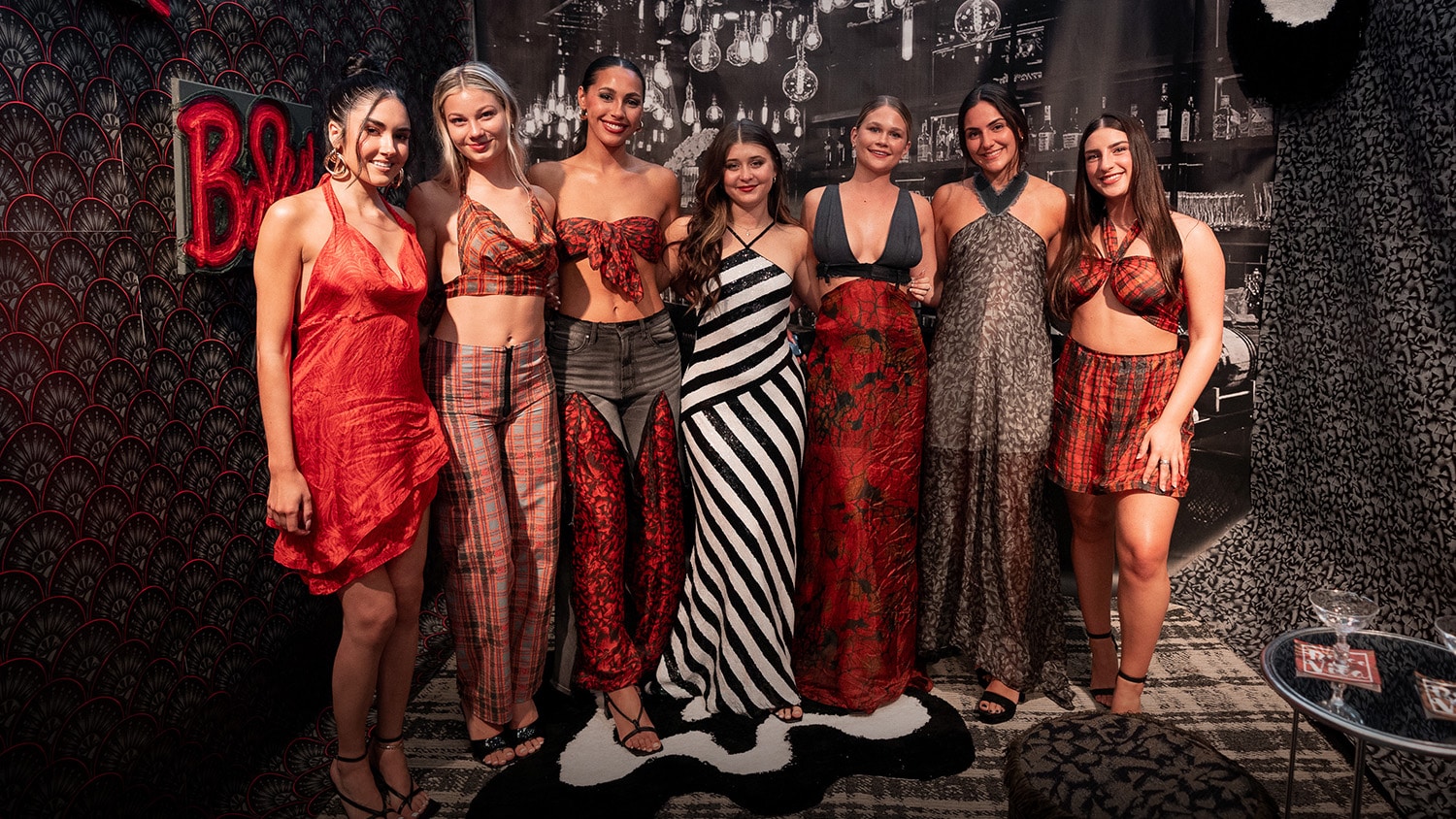 A Wilson College of Textiles student stands with models wearing her capstone collection from the FTD Emerging Designers Showcase.
