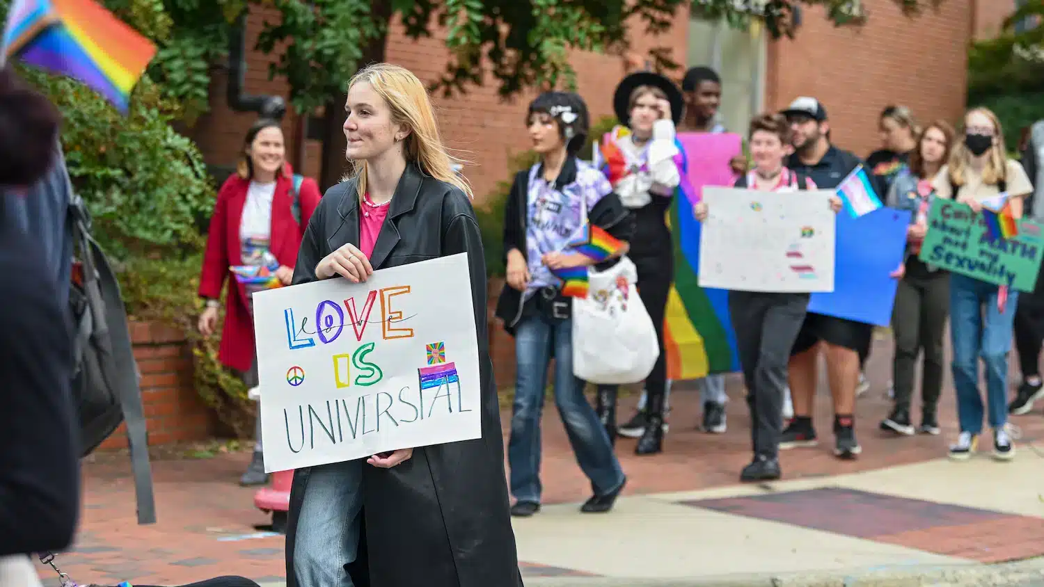 A student holds a sign that says 