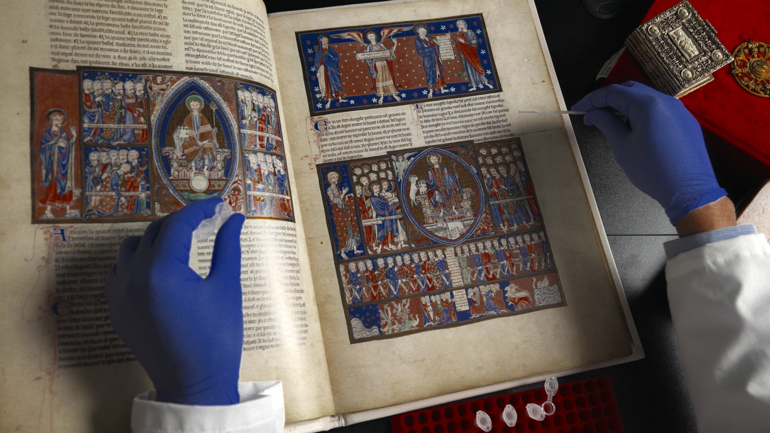 Passing a cytology brush along a 15th-century religious manuscript, English professor Tim Stinson demonstrates a method of obtaining DNA samples from old parchment.