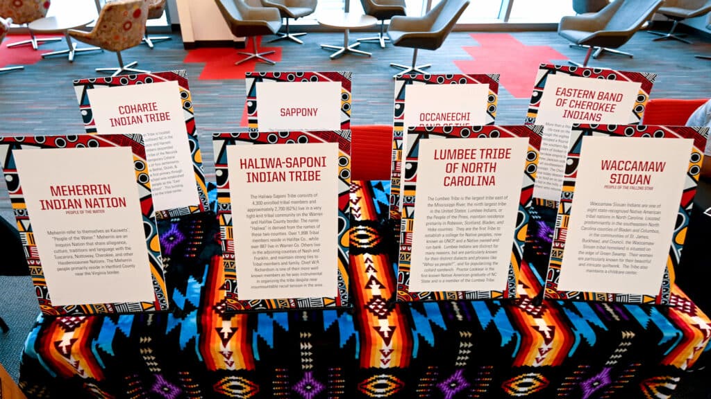 A table has eight flyers, one for each Indigenous tribe recognized in North Carolina.