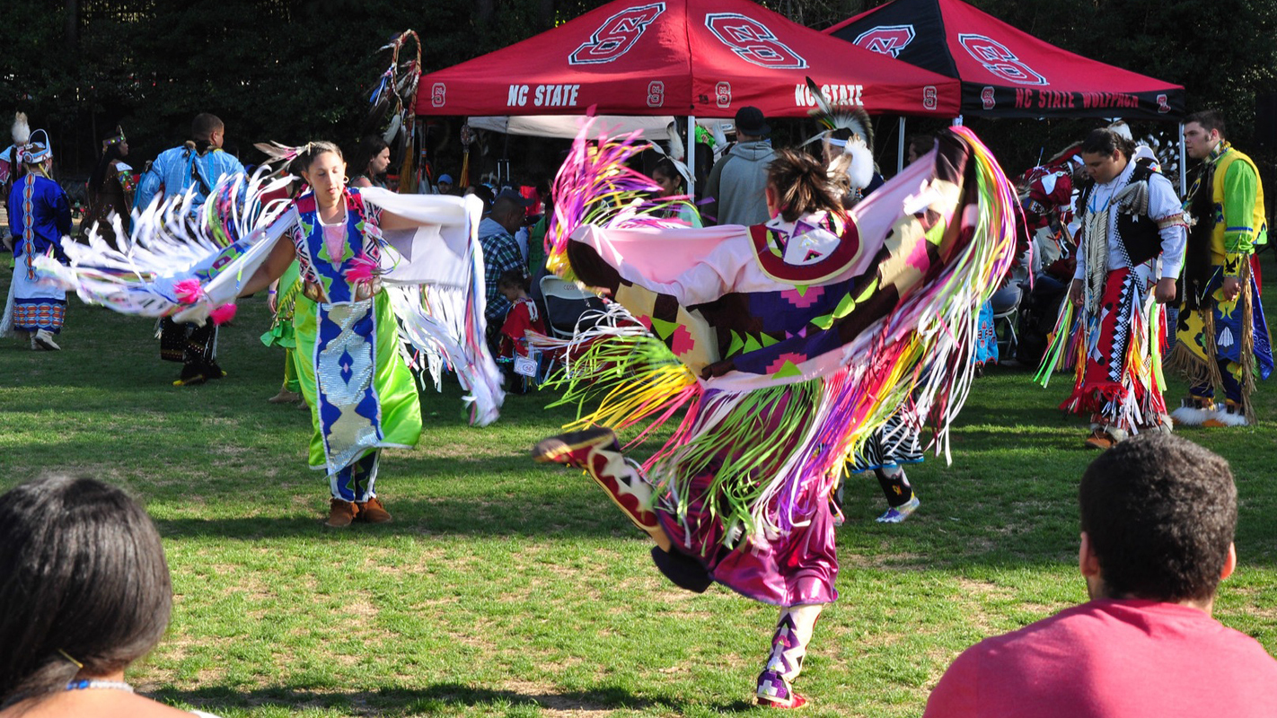 Two performers in traditional Native dress dance at NC State's annual Powwow.