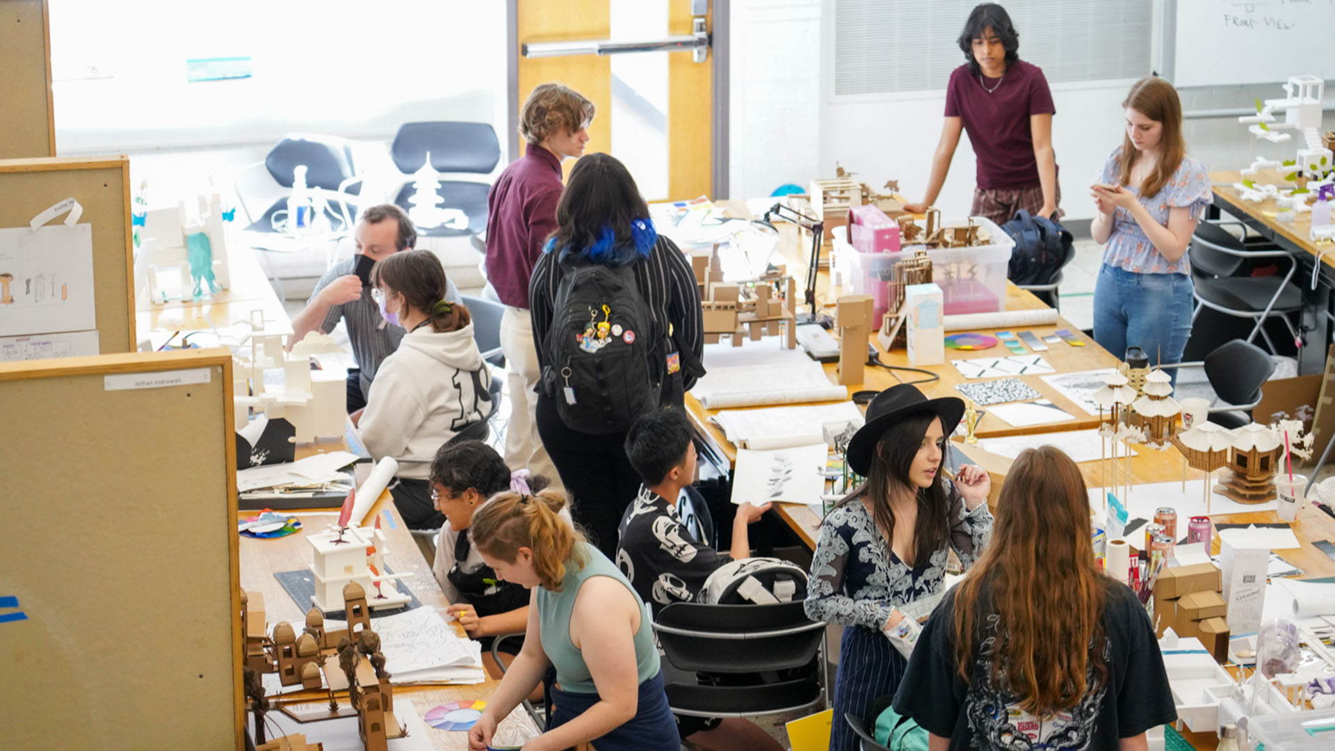 Students in the College of Design collaborate over tables in an on-campus studio.