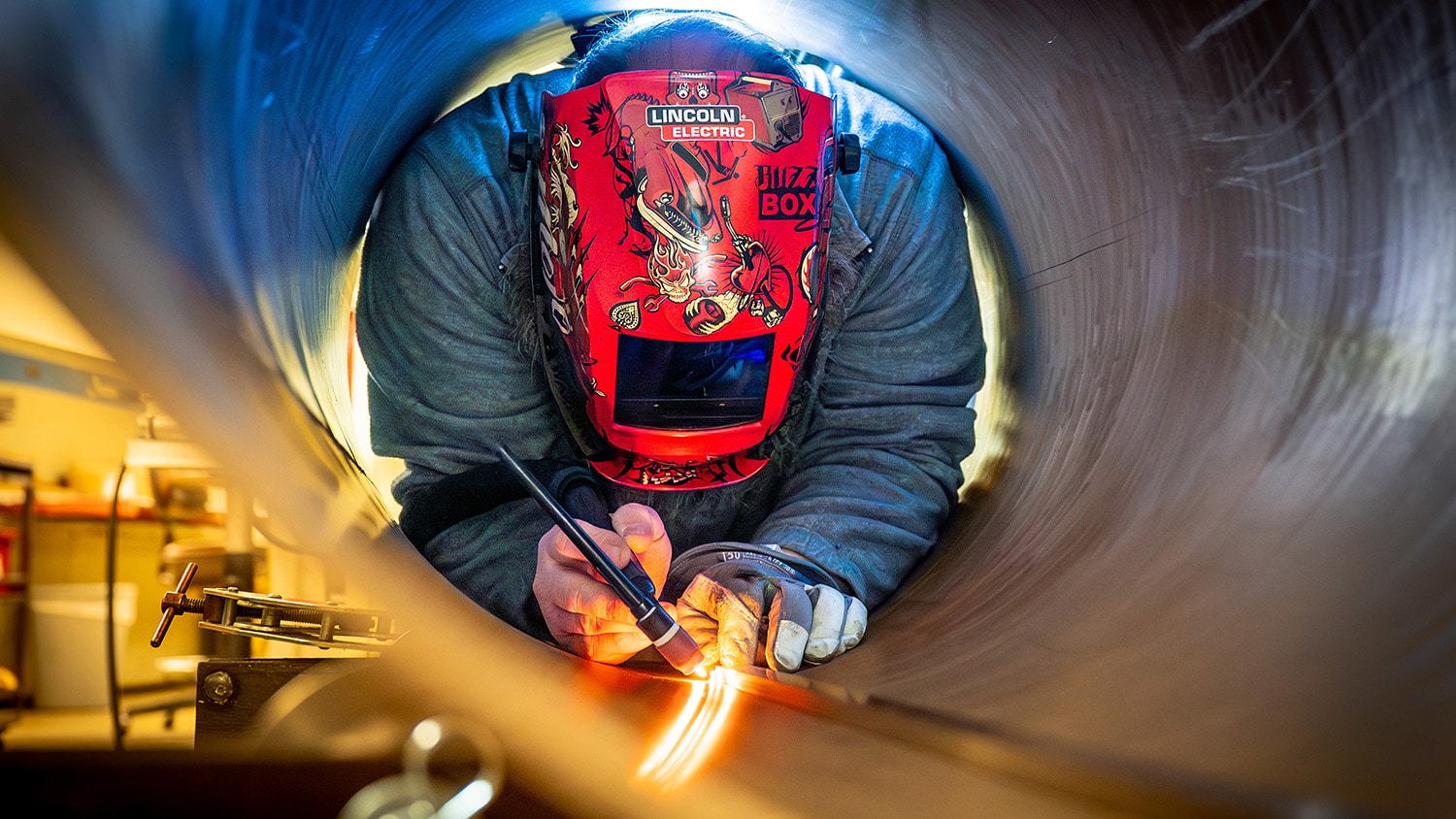 Machinist Chris Hewett welds on the roundhouse, a stainless steel cylindrical structure