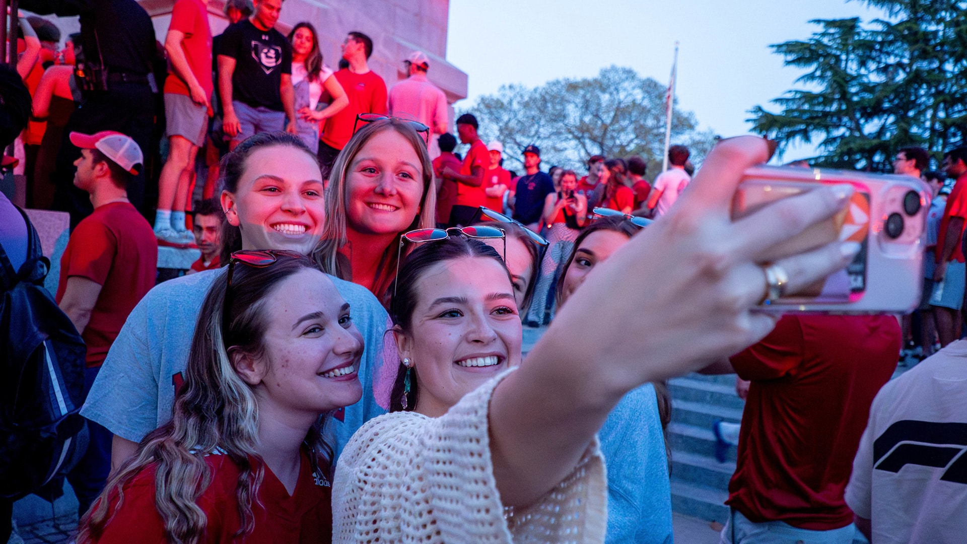 Students snap a selfie at the Memorial Belltower during March Madness celebrations.