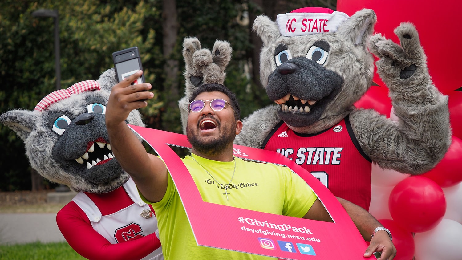 A student snaps a selfie with Mr. and Ms. Wuf on Day of Giving.