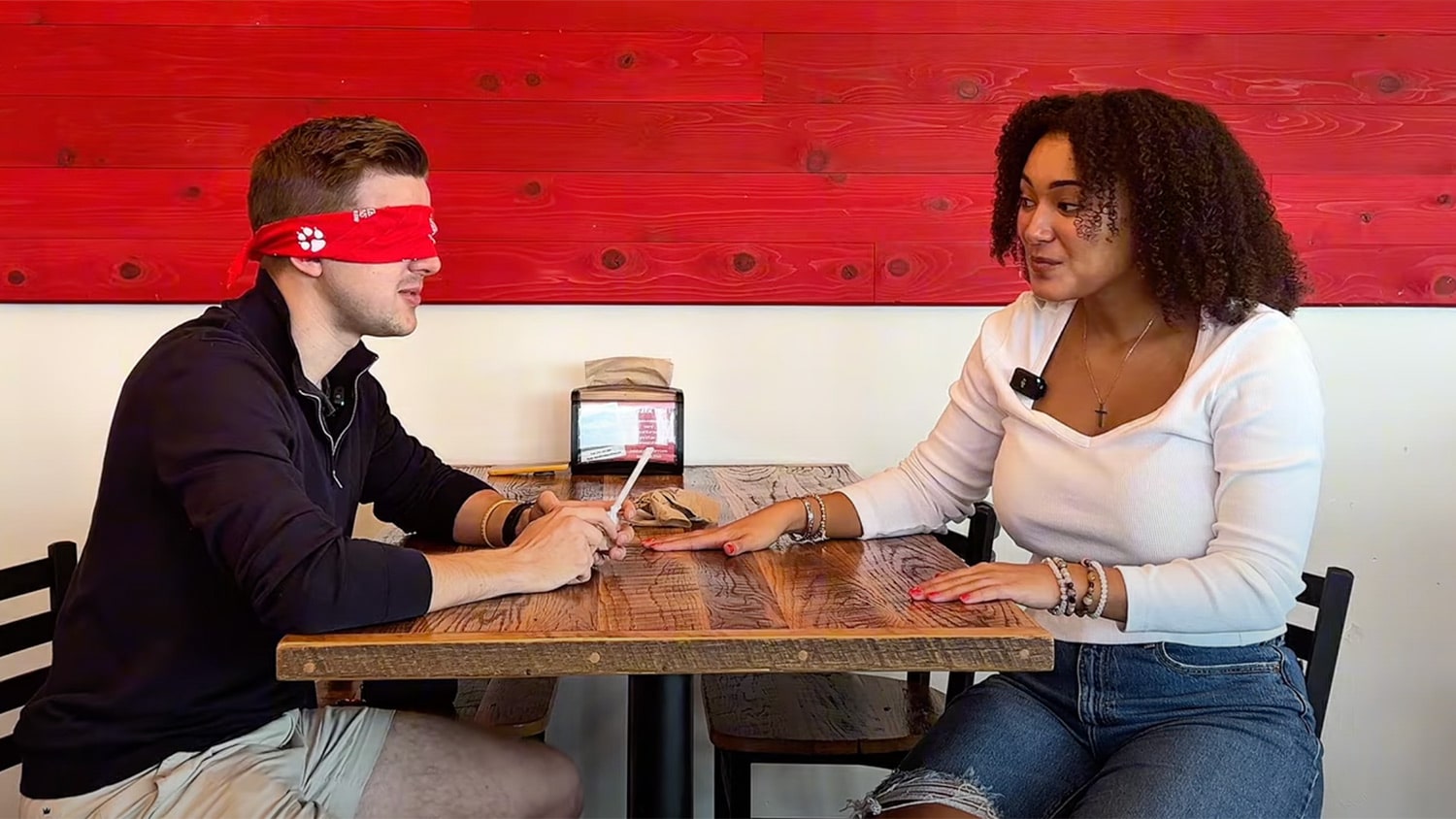 Shaun wears a blindfold and Emma hands him a cup of Howling Cow ice cream.