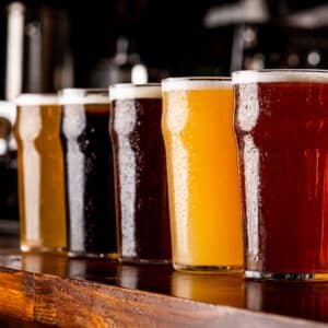 A lineup of craft beers in glasses.