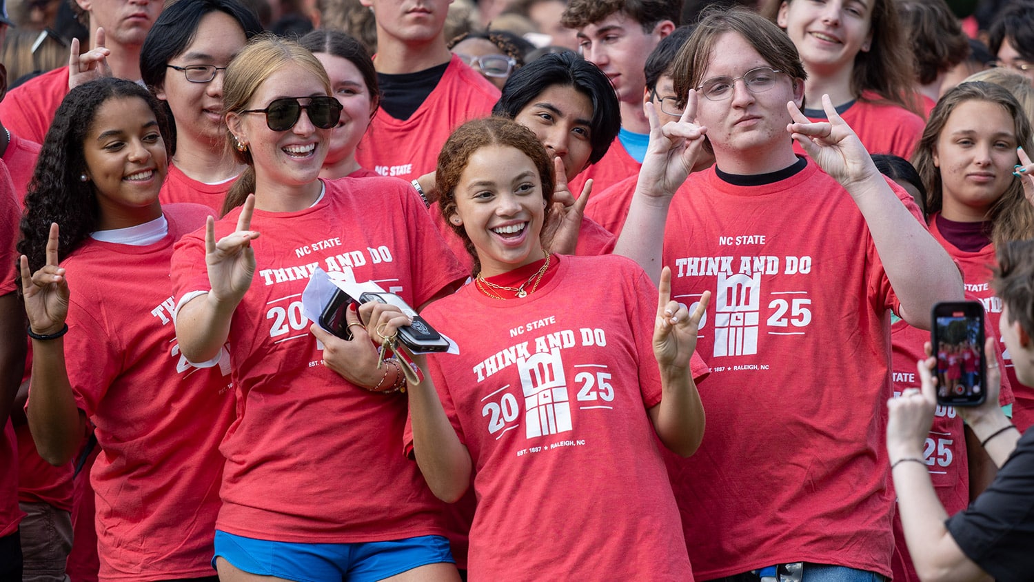 A group of students wearing matching NC&#160;State 2025 T-shirts poses for a photo.