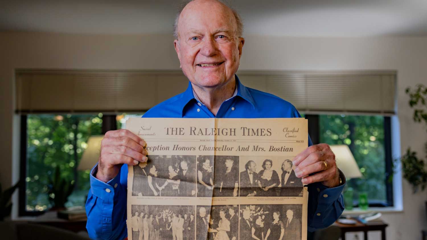 Loyd Bostian holds up a newspaper celebrating his father’s installation as NC State’s seventh chancellor.