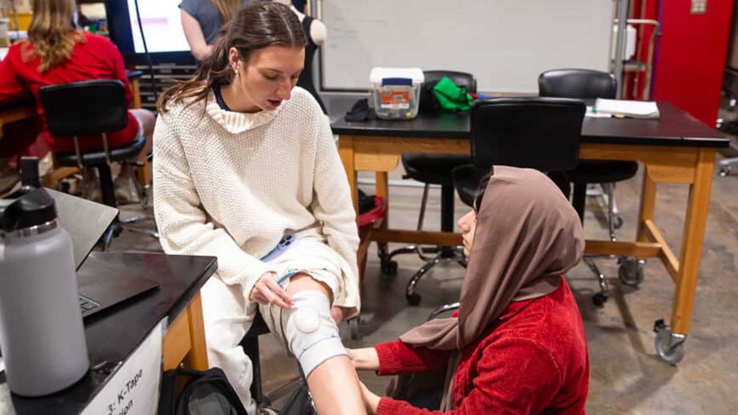 NC State textiles students test out the compressive knee sleeve they created.